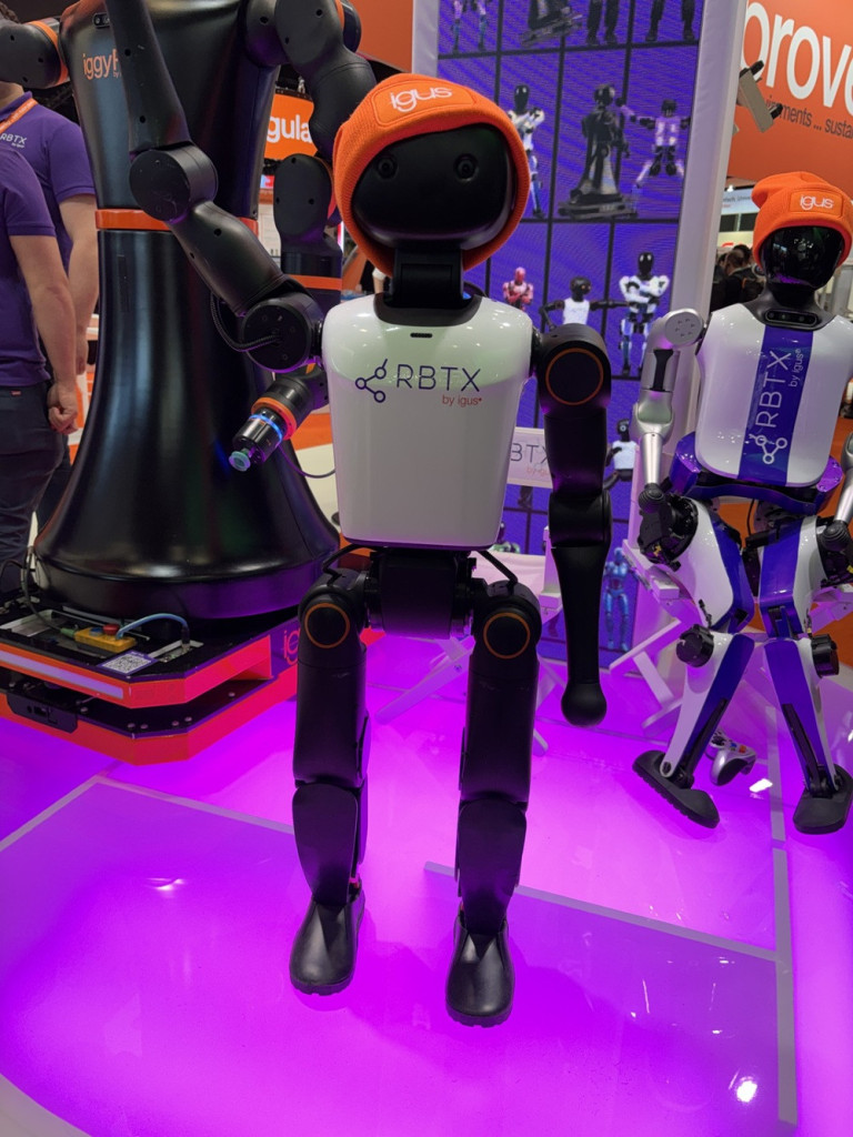 Roboter mit Mütze auf Messe, RBTX by igus, humanoider Roboter mit orangefarbener Mütze