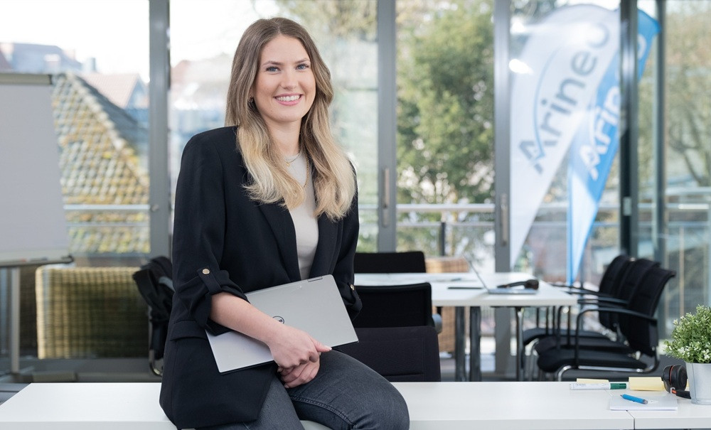 Mitarbeiterin von Arineo mit Laptop im modernen Büro, Arineo Thöle