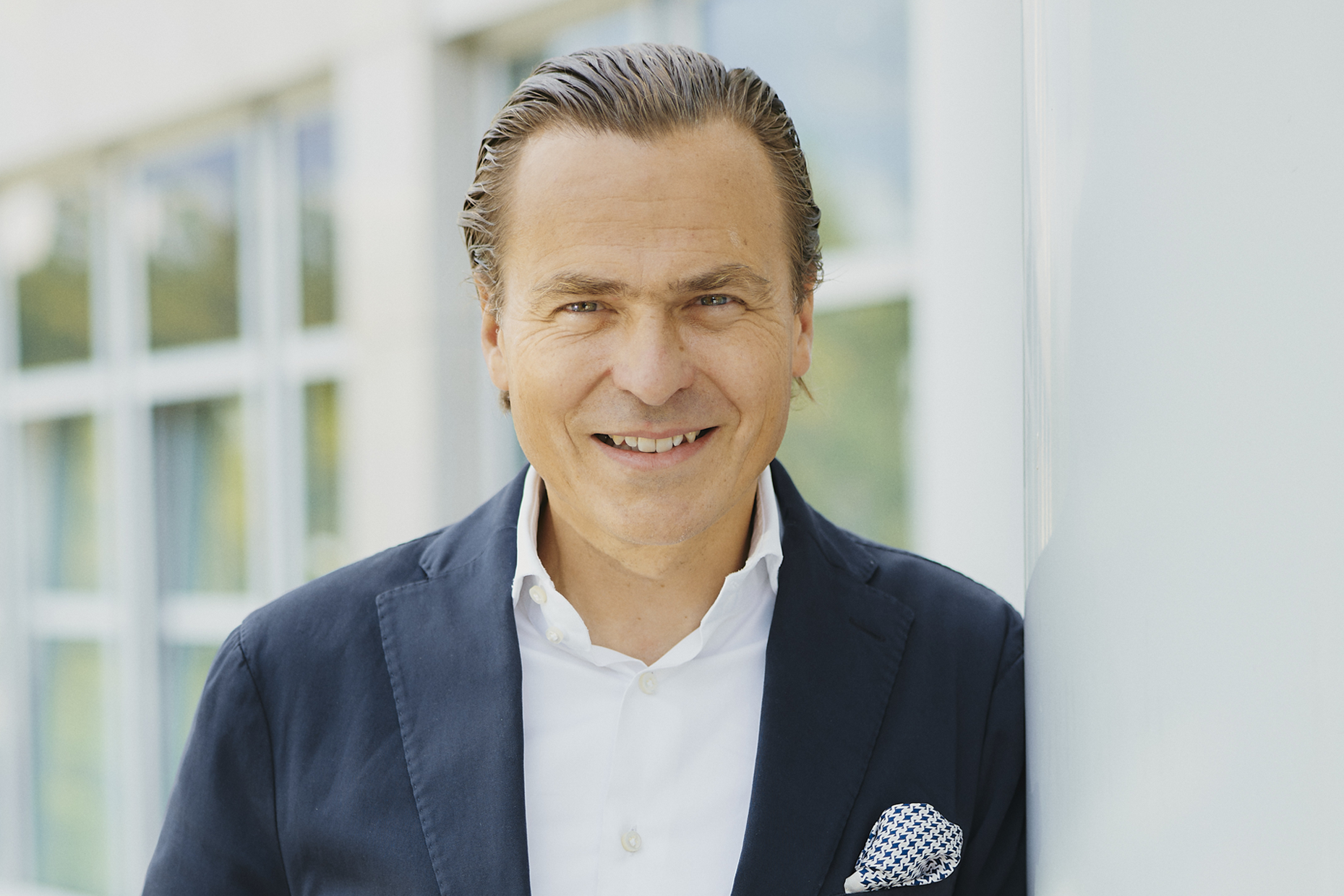 Porträtfoto von Ansgar Heise im Anzug, aufgenommen vor einem modernen Gebäude