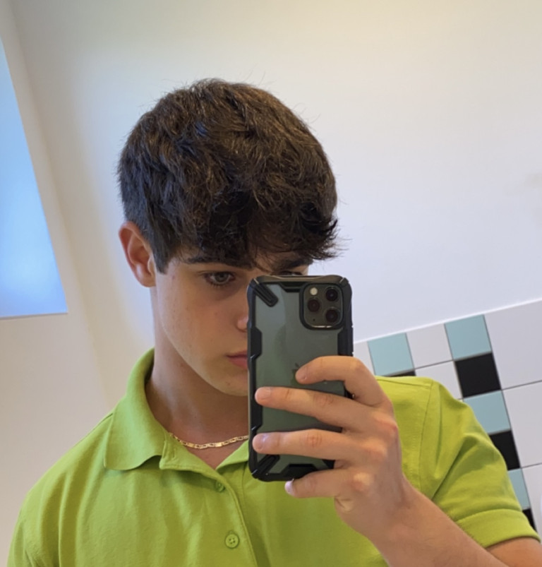 Fabio Klein macht ein Selfie im Spiegel mit grünem Polohemd