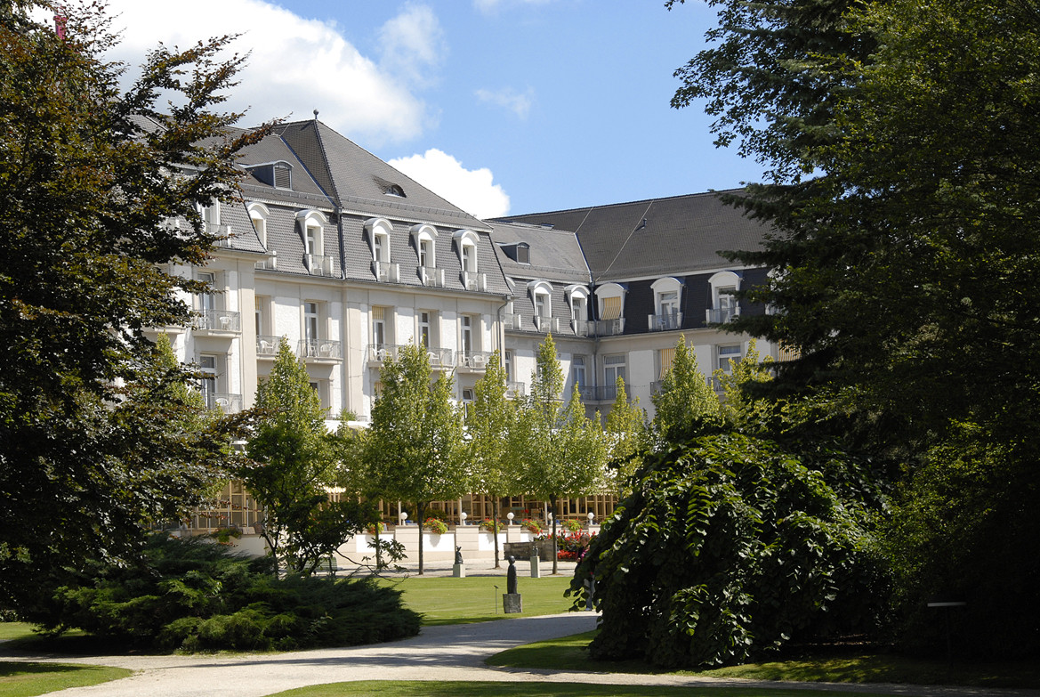 Kurpark Grandhotel mit gepflegtem Garten und klassischer Fassade bei Sonnenschein
