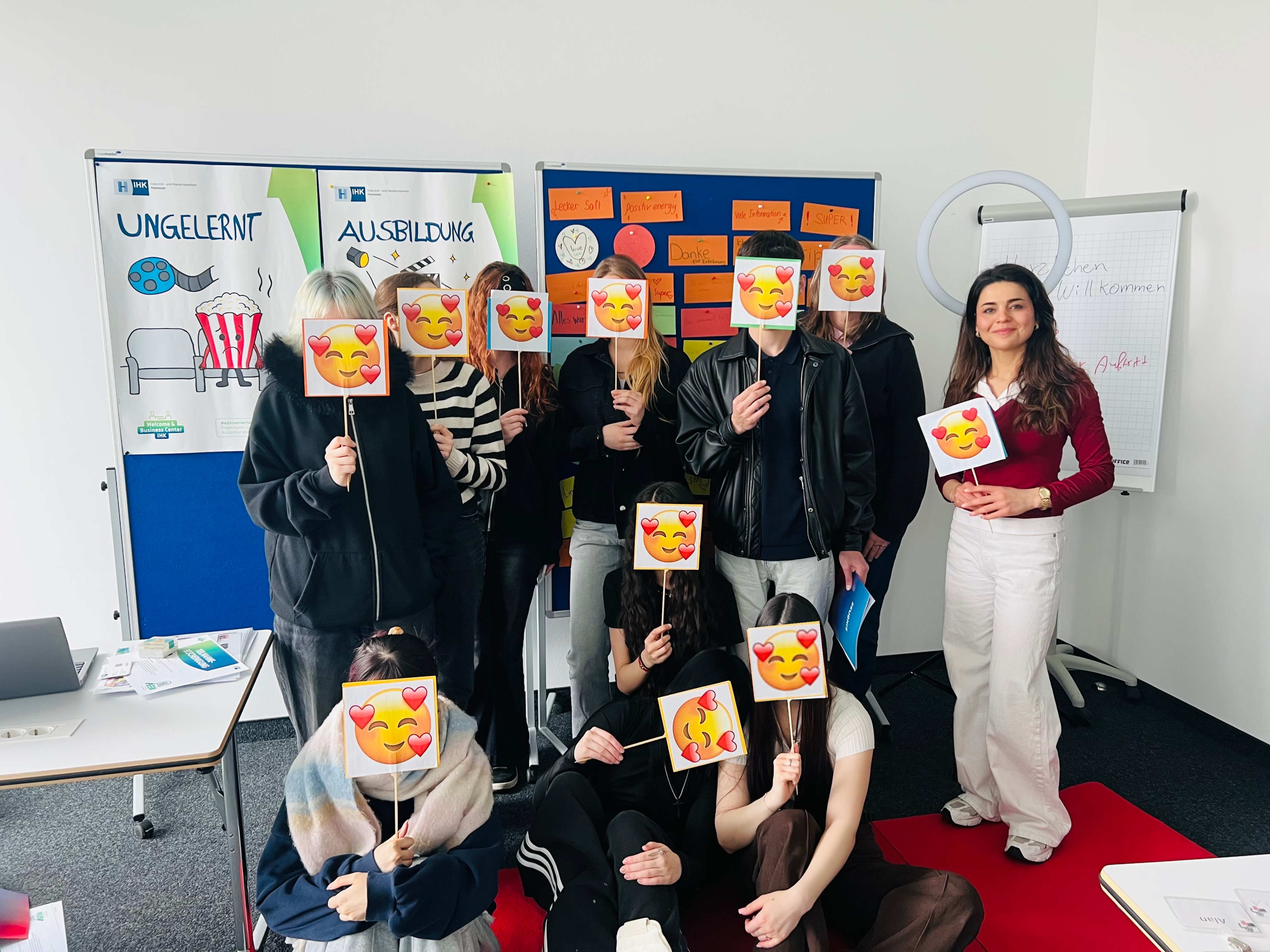 Gruppenfoto beim Talent-Coach-Workshop mit Lina Adil Bibo, Teilnehmerinnen und Teilnehmer halten Emoji-Schilder vor dem Gesicht