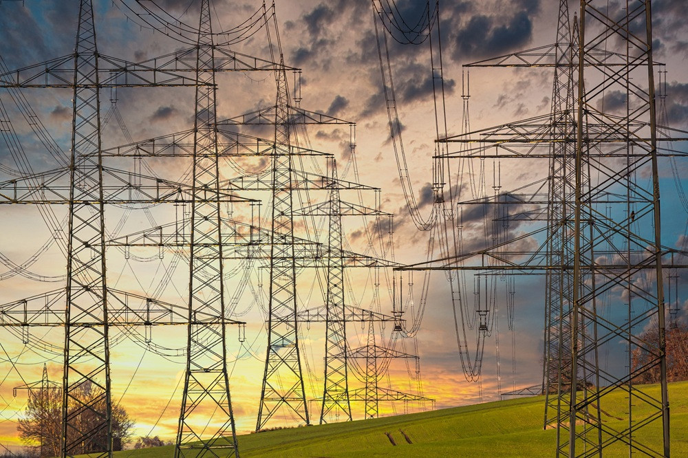 analogicus electricity Strommasten bei Sonnenuntergang auf einer Wiese