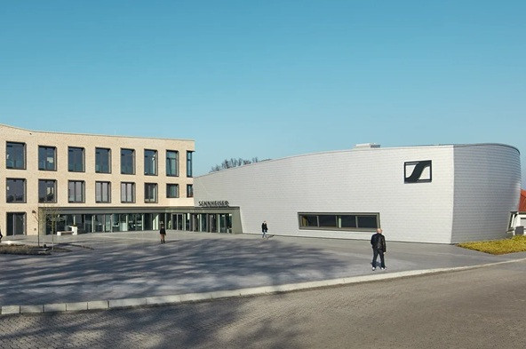 Sennheiser Firmengebäude mit Logo und Eingangsbereich bei Tageslicht