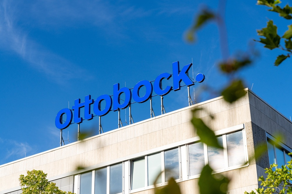 Ottobock Zentrale mit blauem Firmenschild auf dem Dach vor blauem Himmel