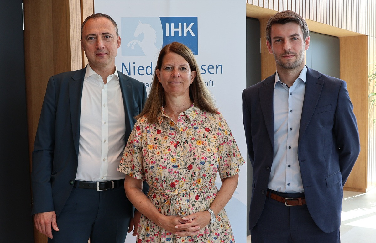 Drei Personen vor IHK Niedersachsen Banner, Gruppenfoto bei einer Veranstaltung