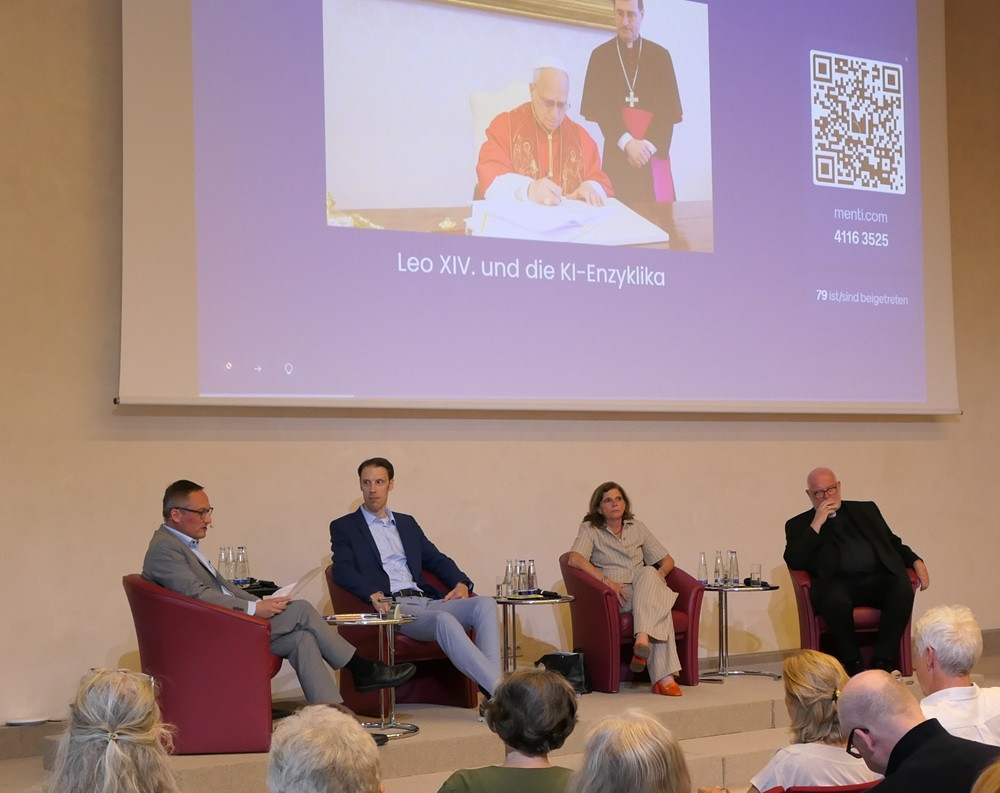 Podiumsdiskussion mit vier Personen vor einer Leinwand mit dem Thema 'Leo XIV. und die KI-Enzyklika'