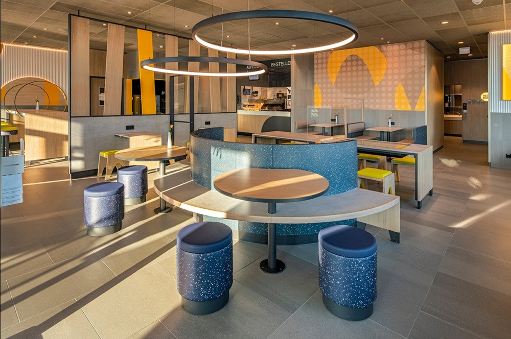 Modernes Restaurant-Interieur gestaltet von Ehmann Design, Sitzbereich Luna mit runden Tischen und stilvoller Beleuchtung