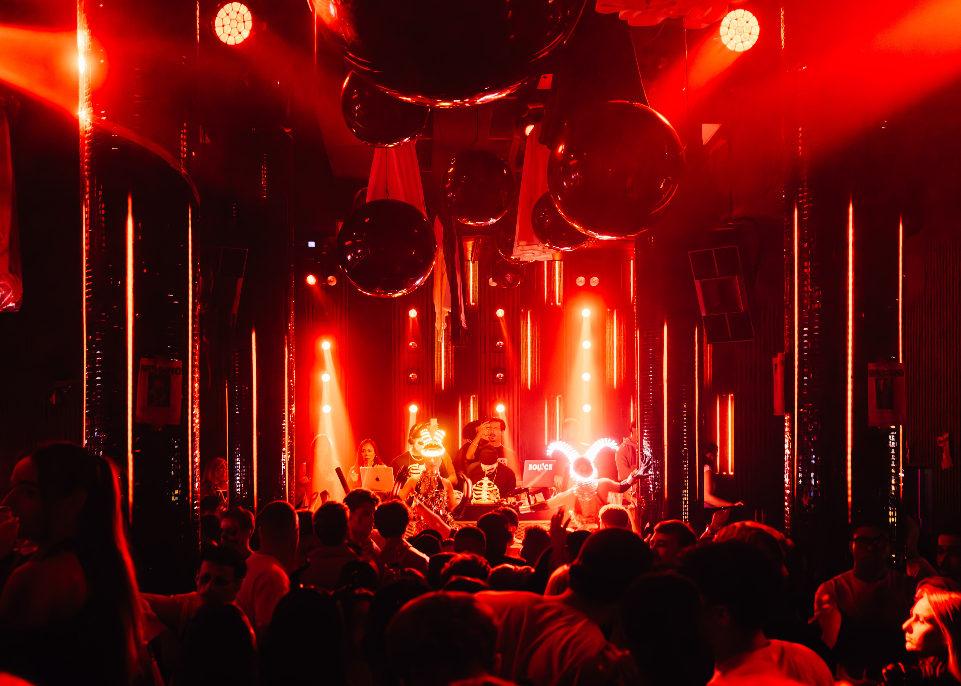Party im Savoy Club mit DJ und tanzender Menge unter roten Lichtern