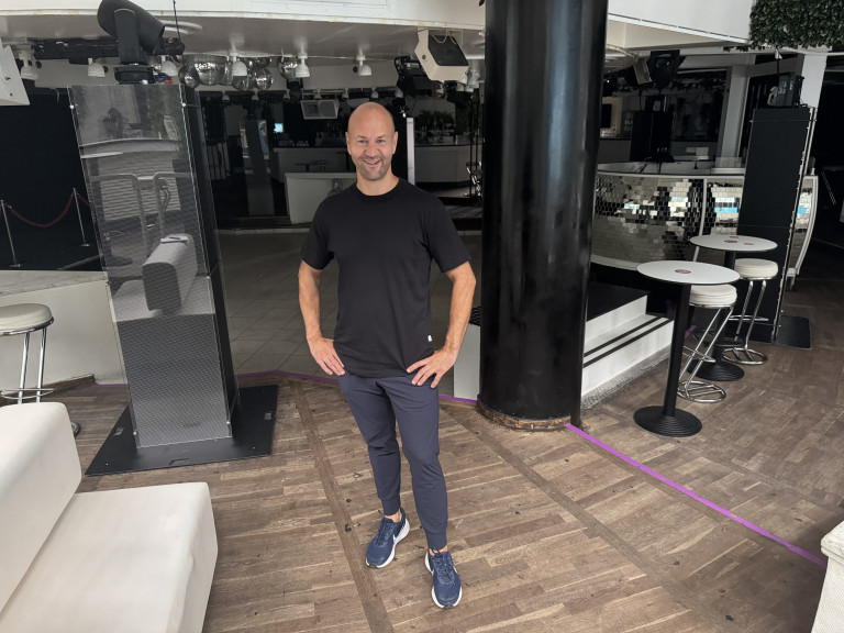 Lächelnder Mann in moderner Bar oder Club in Freizeitkleidung Mann steht lächelnd in moderner Bar oder Club, Freizeitkleidung, entspannte Atmosphäre