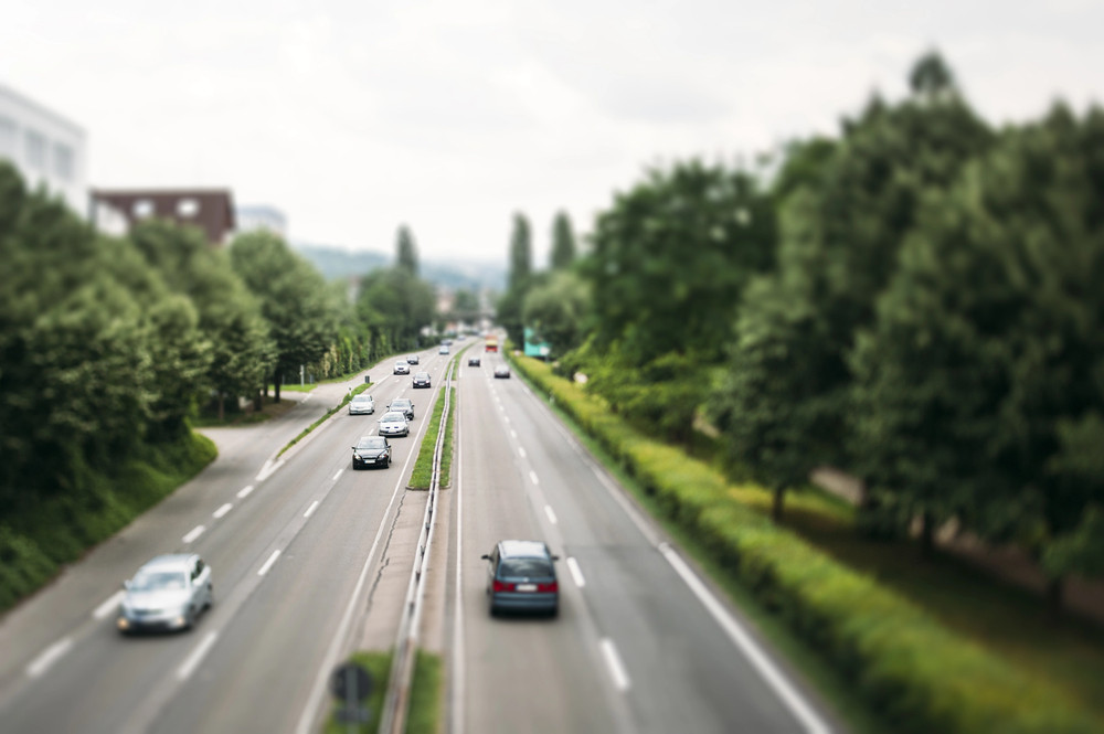 stock image 45127911 m – Autos auf einer zweispurigen Straße mit Bäumen an den Seiten