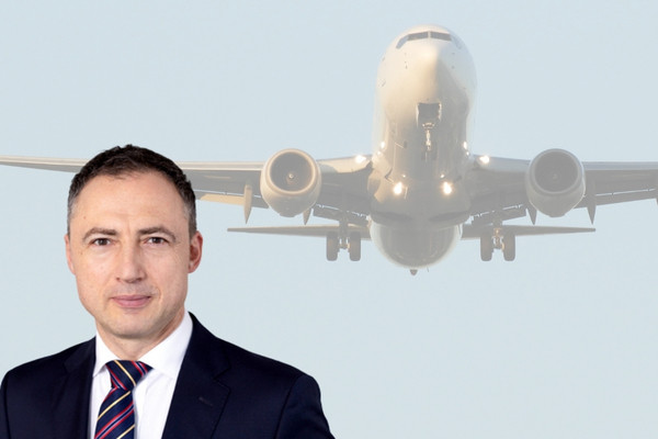 Geschäftsmann vor landendem Flugzeug für Newsletter Ausgabe 32 grosse gt 3
