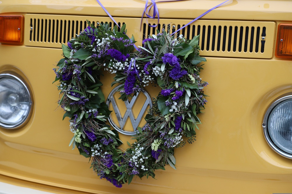 Blumengesteck in Herzform an gelbem VW-Bus, Foto von Philipp Heister