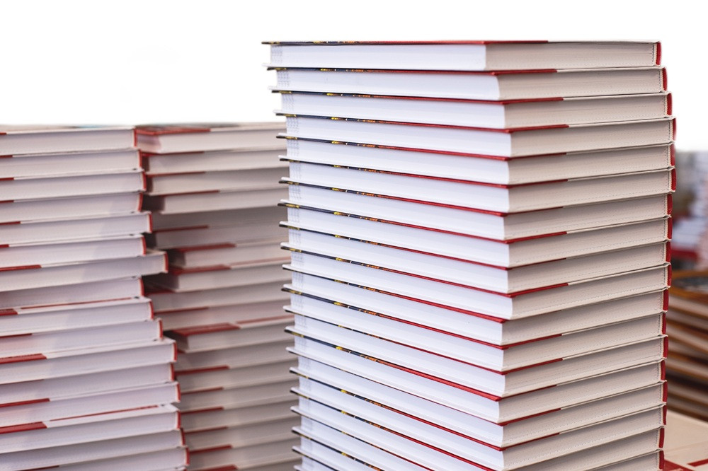 Mehrere gestapelte Hardcover-Bücher, Nahaufnahme, adobestock-500456576-web