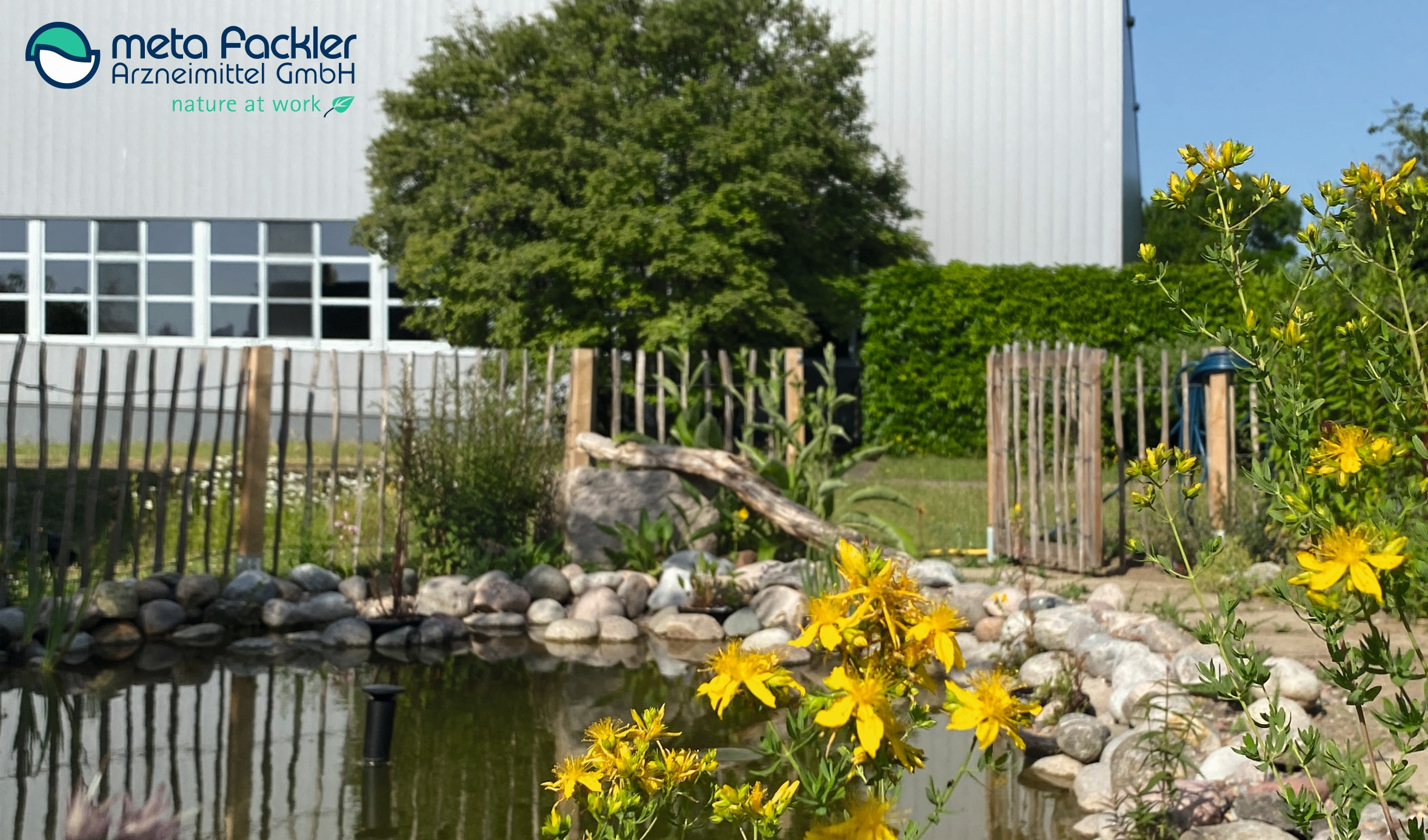 Logo vor Teichanlage mit Blumen und Natur im Hintergrund
