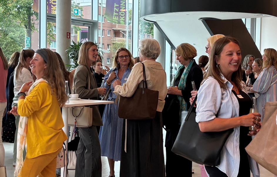 Netzwerktreffen von Frauen in der Midlife-Phase bei einem Event, Austausch und Gespräche in moderner Umgebung