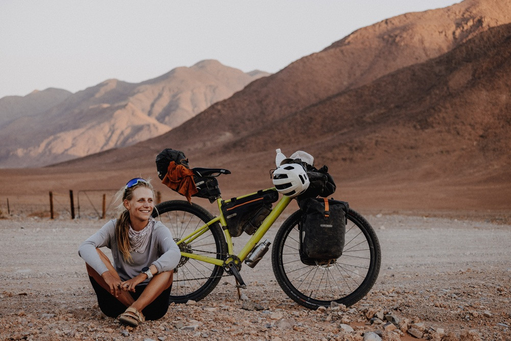 Wiebke Luhmann mit Fahrrad in bergiger Wüstenlandschaft – Foto von Fabienne Engel
