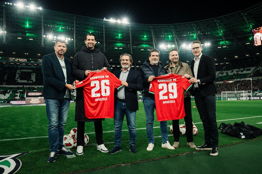 Gruppenfoto von Hannover 96 und Apostels im Stadion mit Trikots