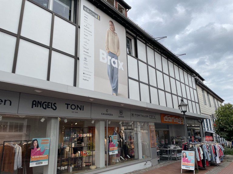 Modegeschäft Döring mit Brax-Werbung und Modemarken wie Angels, Toni und Cecil in der Innenstadt Fassade des Modegeschäfts Döring mit Werbeplakat von Brax und verschiedenen Modemarken in der Innenstadt