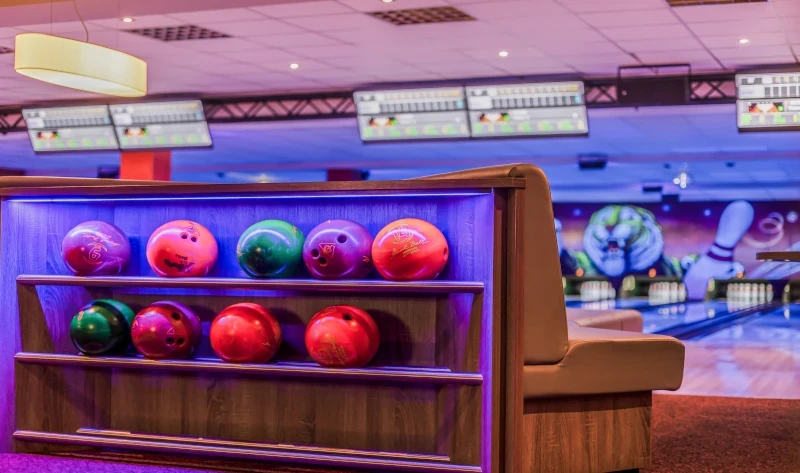 Bowlingkugeln im Regal einer modernen Bowlingbahn – Symbolbild für Bowling Preise