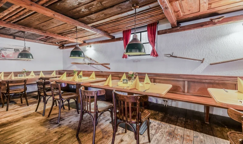 Rustikales Restaurant mit Holzmöbeln und gedecktem Tisch im Landhausstil