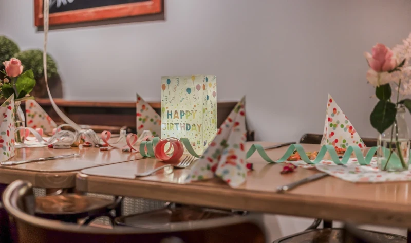 Festlich gedeckter Tisch für einen Kindergeburtstag mit Geburtstagsdeko und Happy Birthday Schild