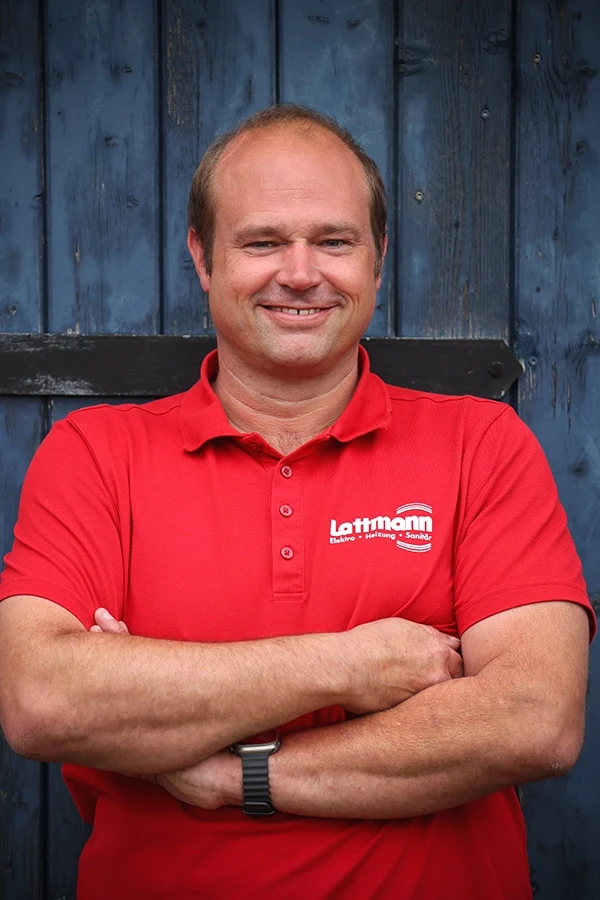 Stefan Lattmann im roten Polo-Shirt Stefan Lattmann im roten Polo-Shirt vor blauer Holzwand