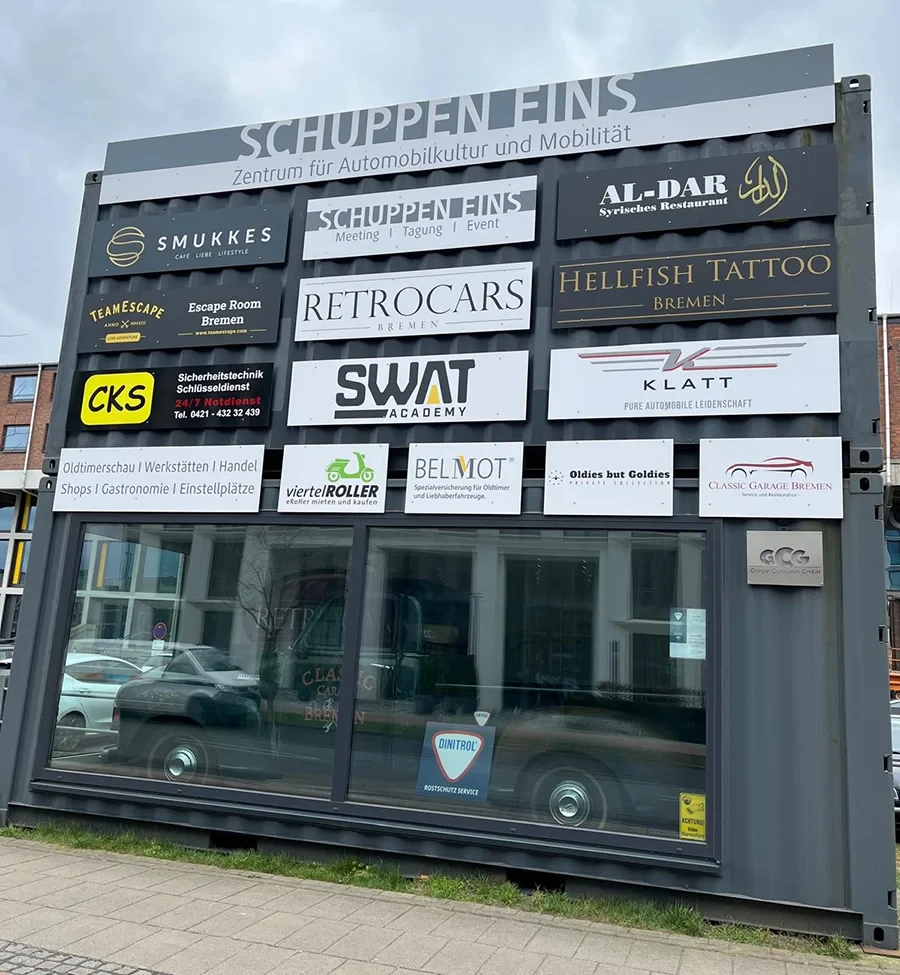 Firmenschilder am Schuppen Eins in Bremen, u.a. Smukkes, Al-Dar, TeamEscape, RetroCars, Hellfish Tattoo, SWAT Academy, Klatt, Classic Garage Bremen