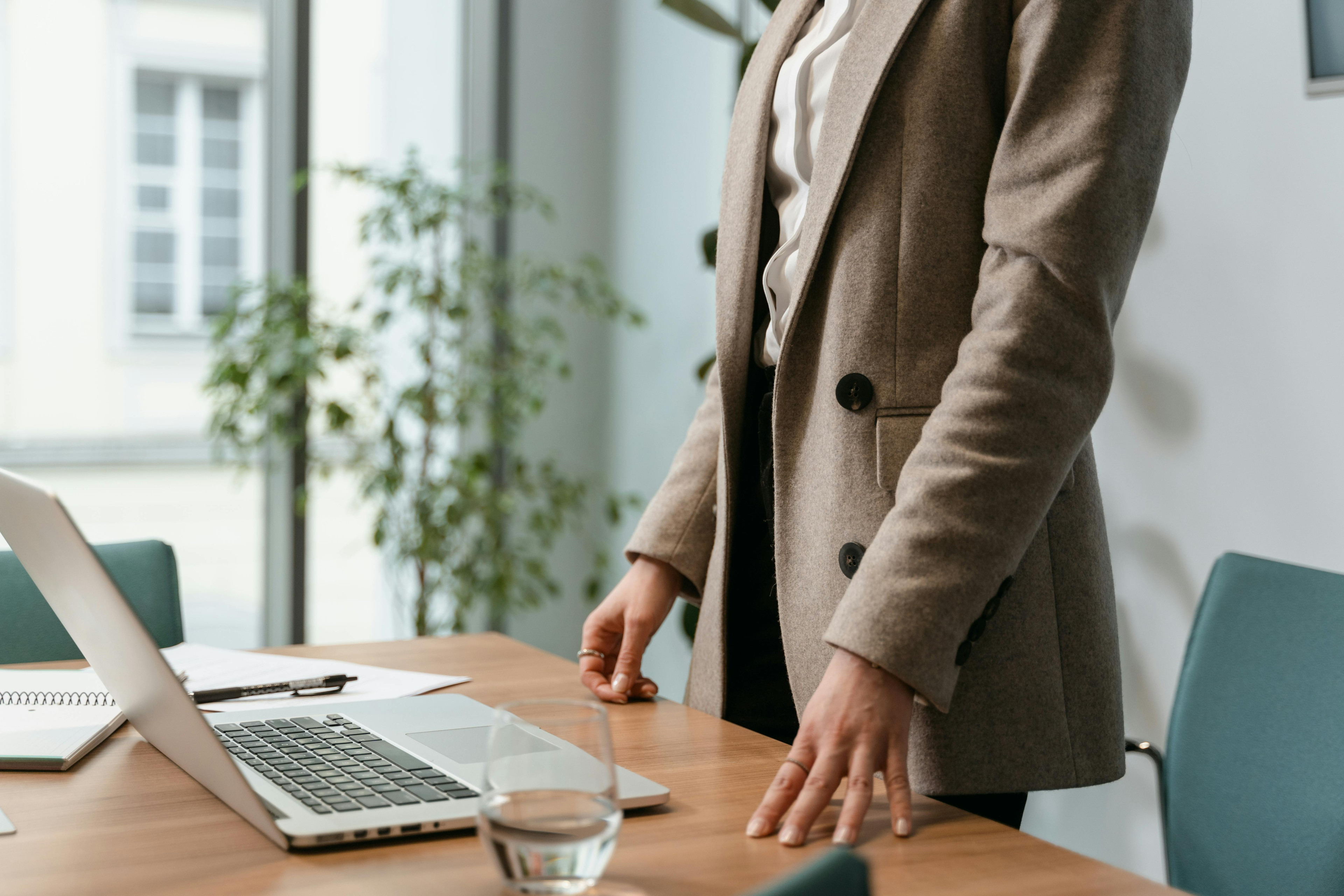 Person im Meetingraum mit Laptop auf dem Tisch