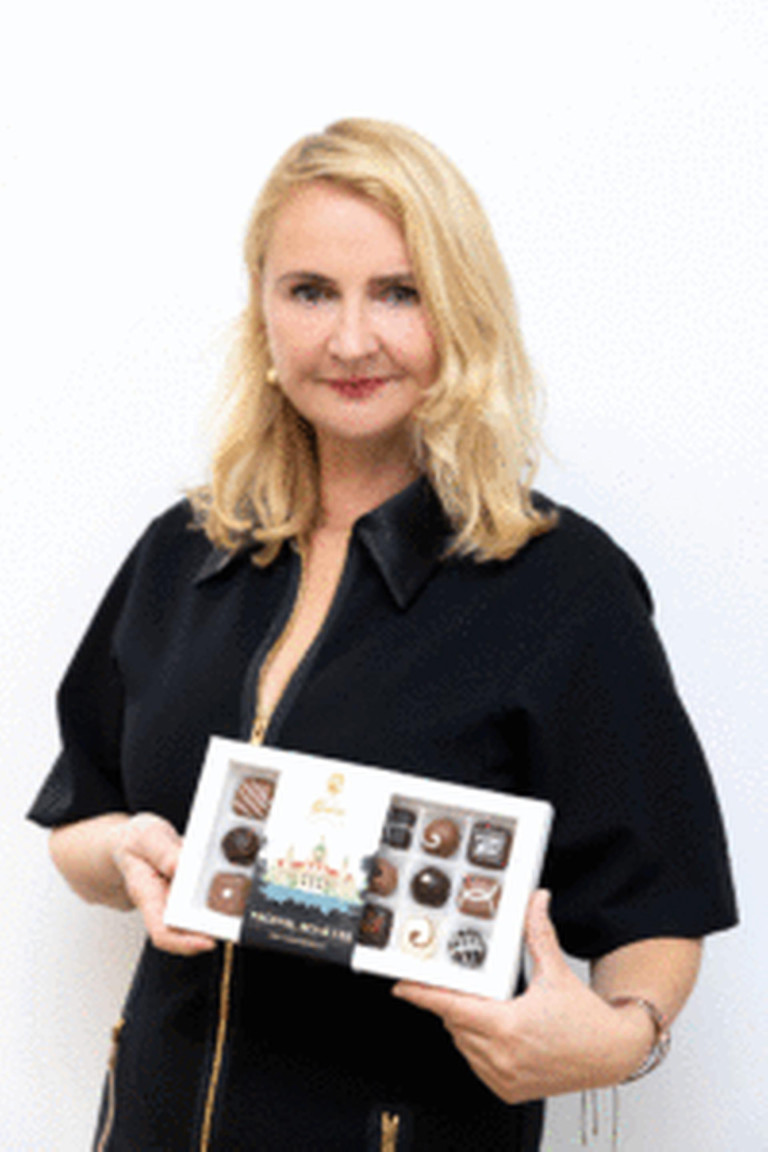 Sabine Güse-Henschel mit geöffneter Pralinenschachtel in den Händen, zeigt feine handgefertigte Pralinen aus der Schokoladenmanufaktur.