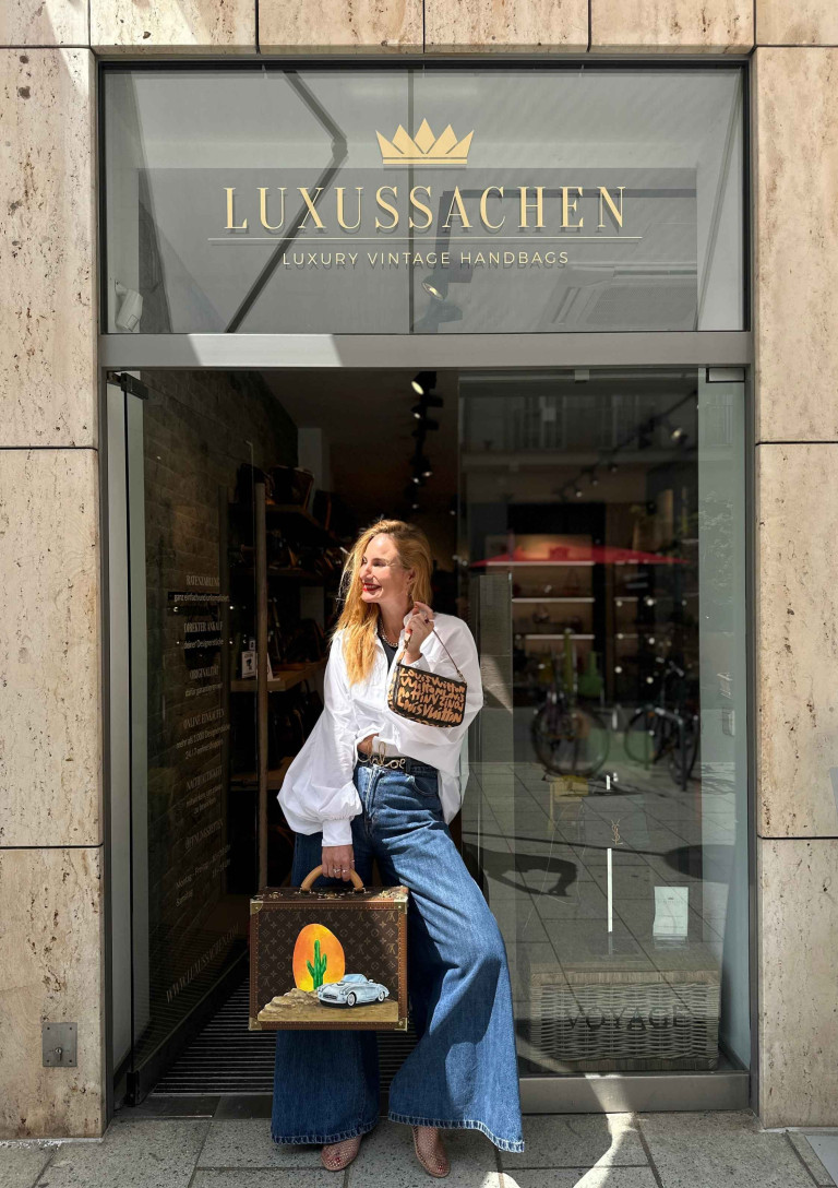 Frau vor Luxussachen-Geschäft mit Vintage-Handtaschen
