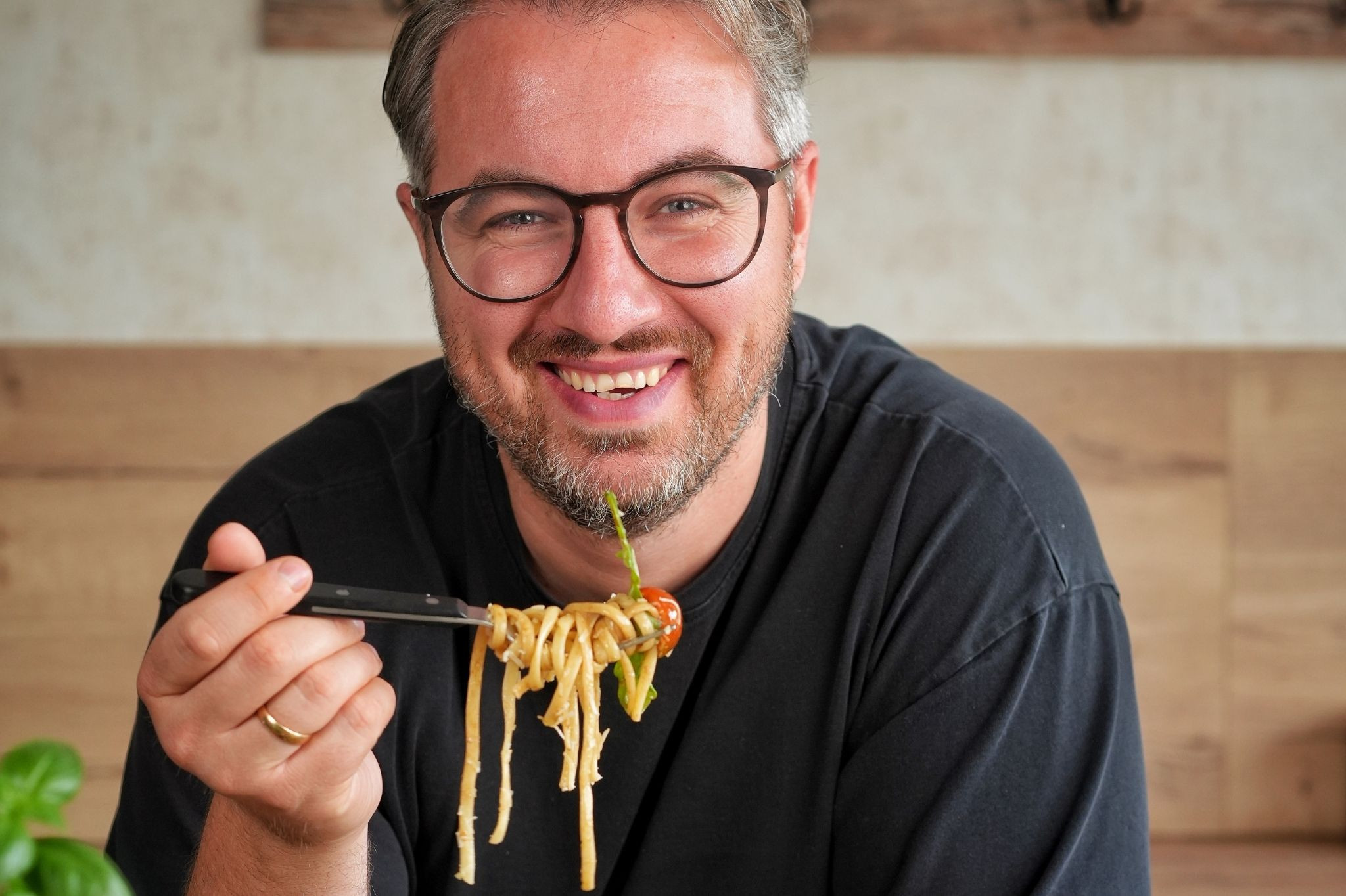 Mann genießt Pasta-Gericht mit Tomaten und Gemüse