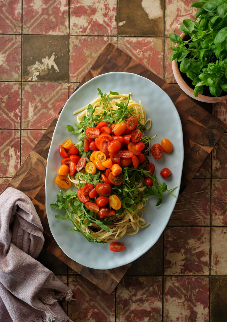 Vegetarische Pasta mit Rucola und Kirschtomaten auf einem Teller
