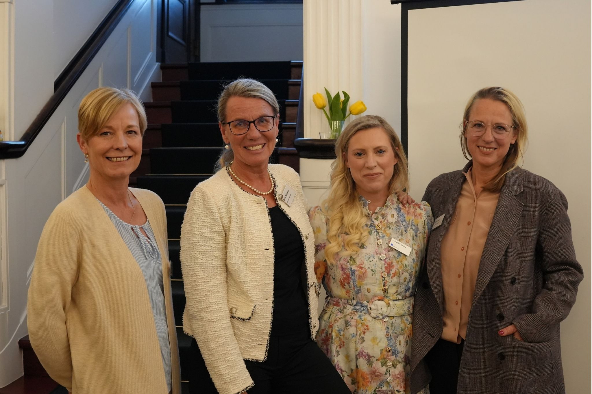 Vier Frauen bei einem Networking-Event vor einer Treppe