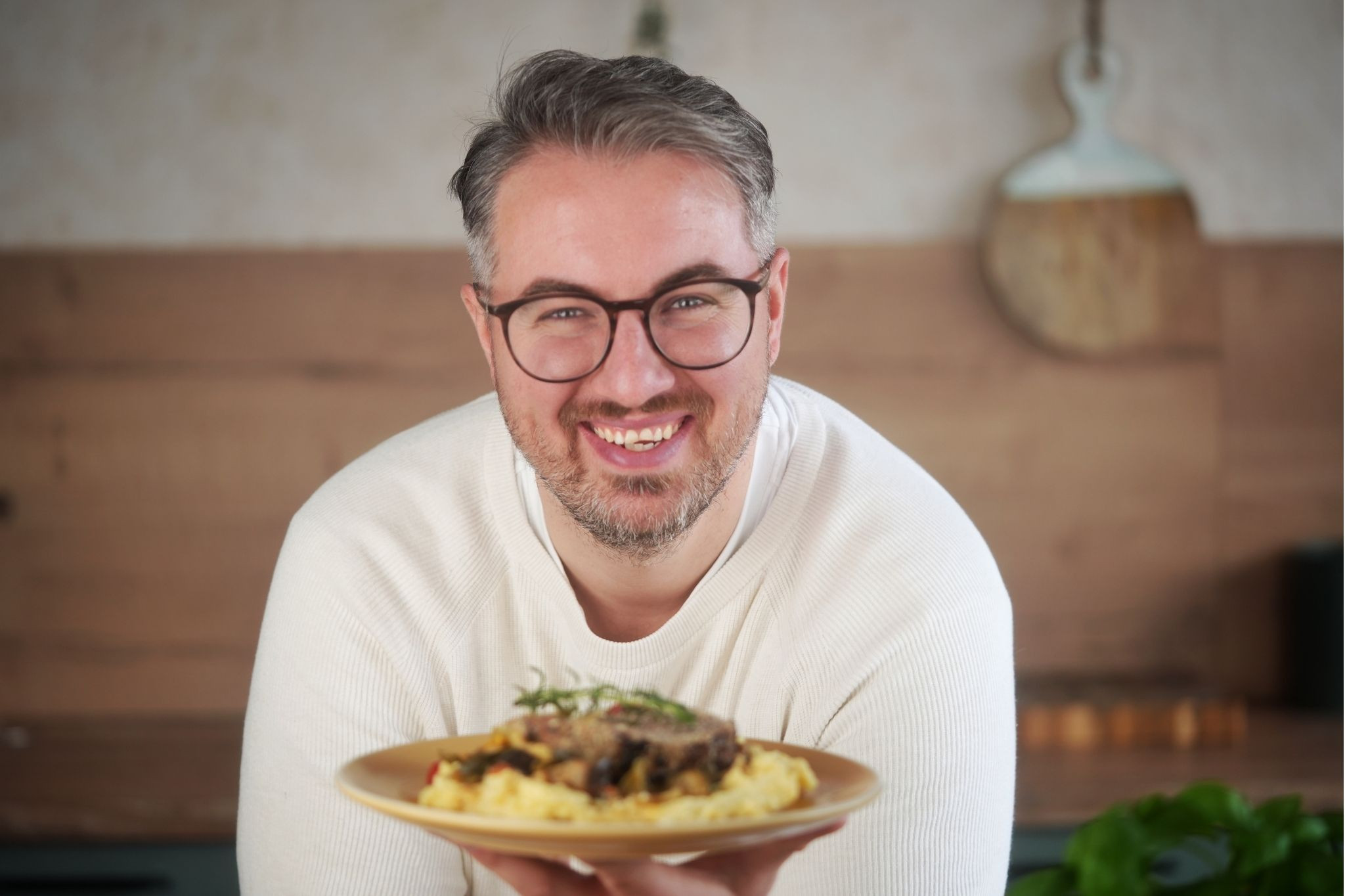 Mann präsentiert Hackbraten auf Teller