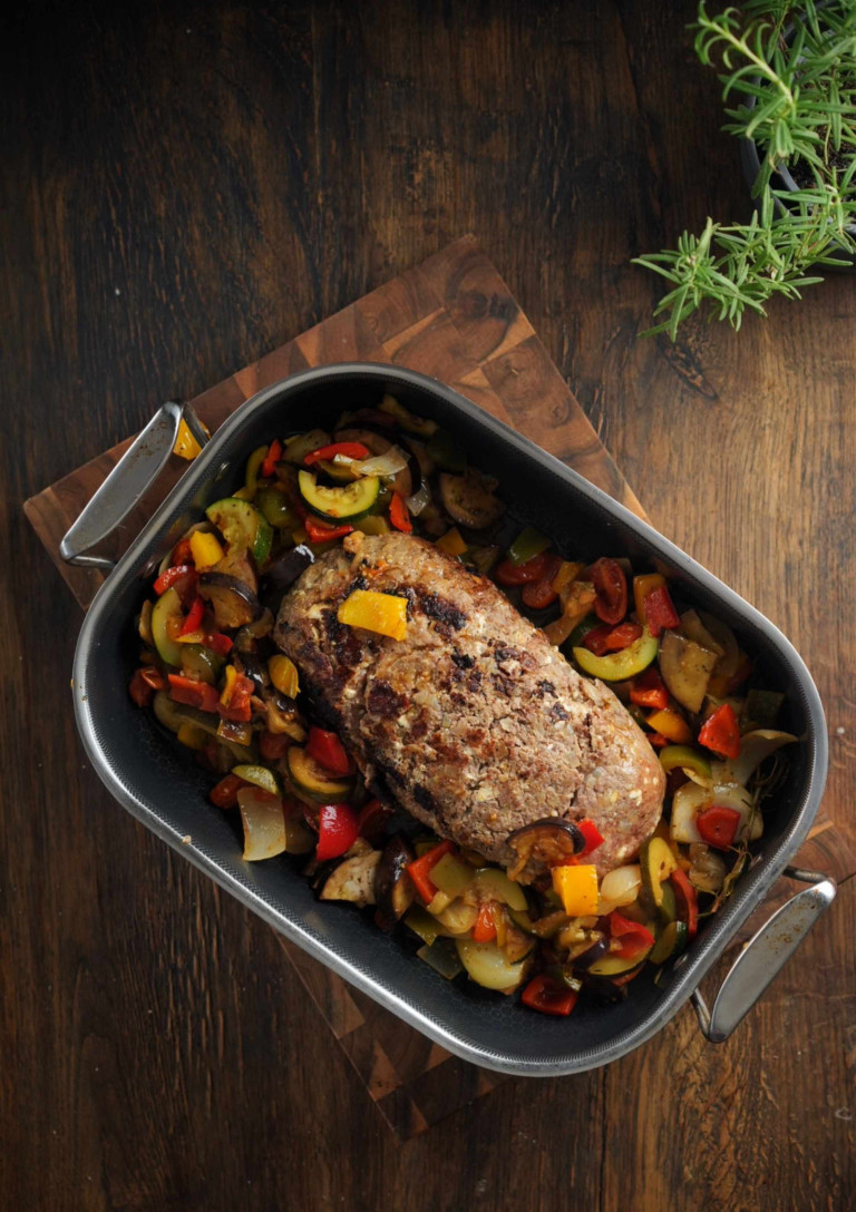 Hackbraten mit Gemüse im Ofen auf einem Holztisch