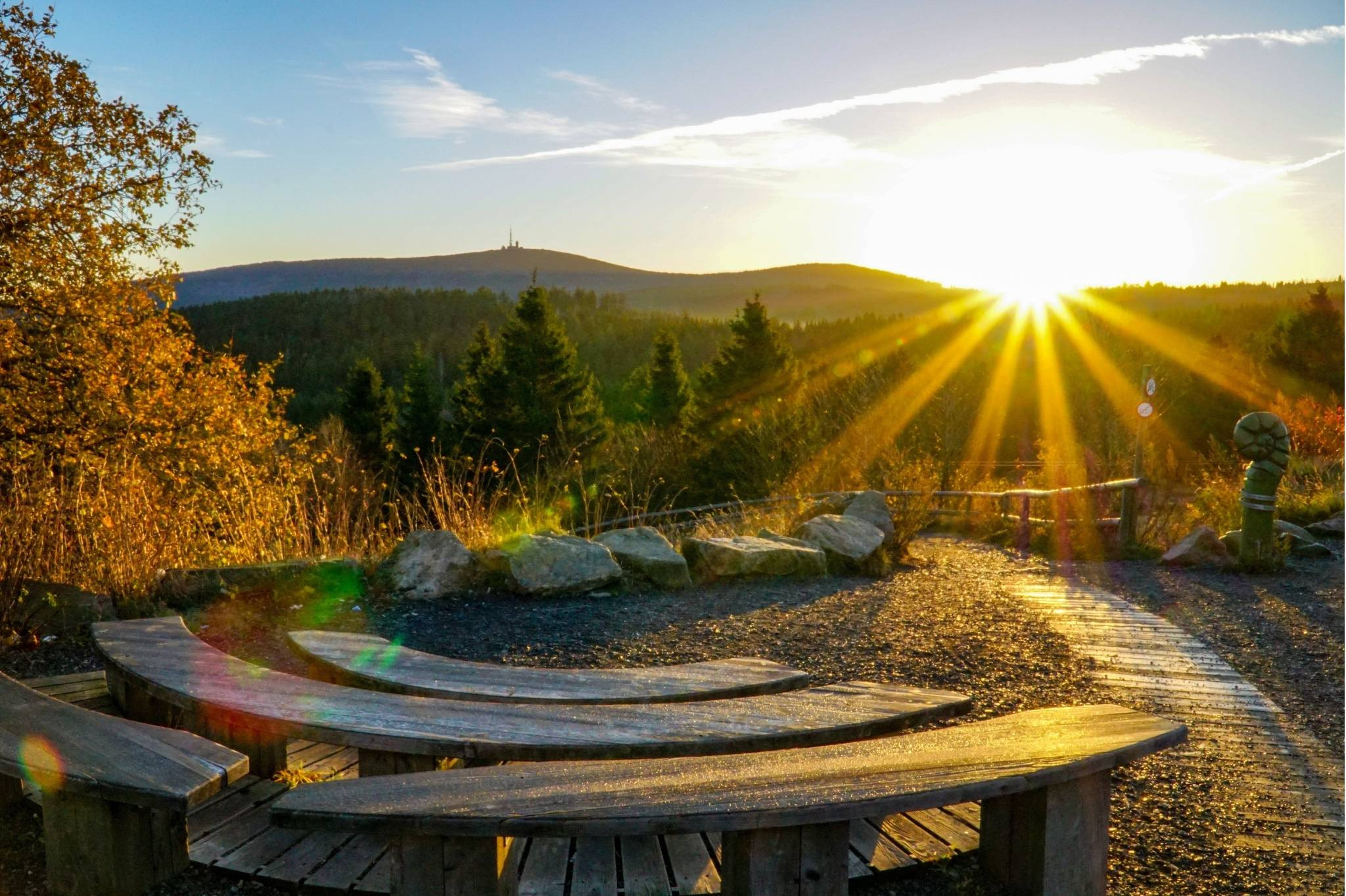 Sonnenaufgang über dem Brocken im Harz Sonnenaufgang über dem Brocken im Harz mit Holzbänken im Vordergrund