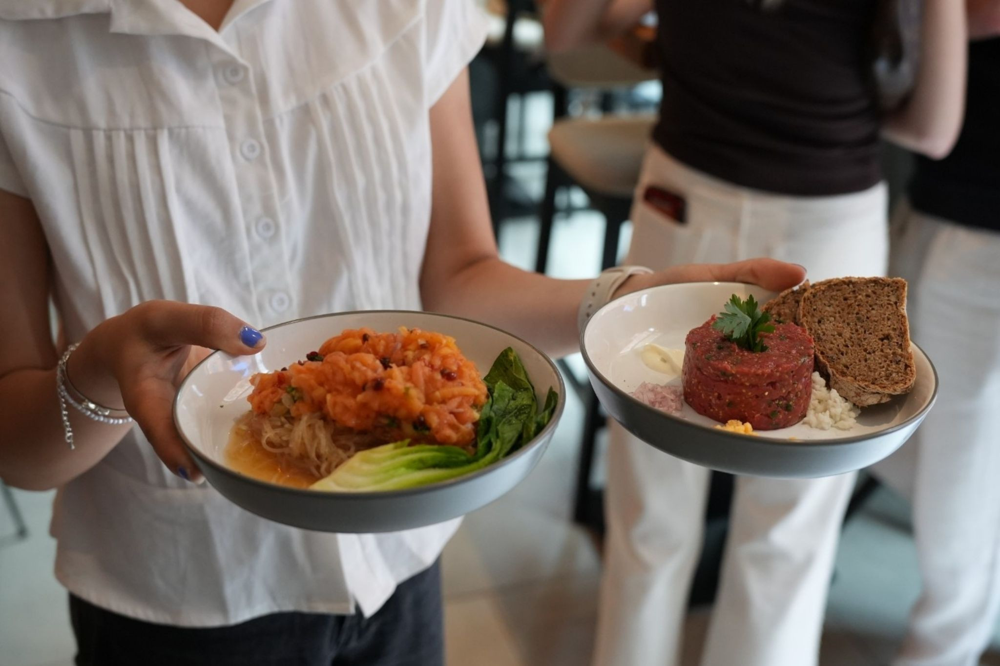 Servieren von Gerichten im Living Bistro – frisches Tatar und Salat auf Tellern