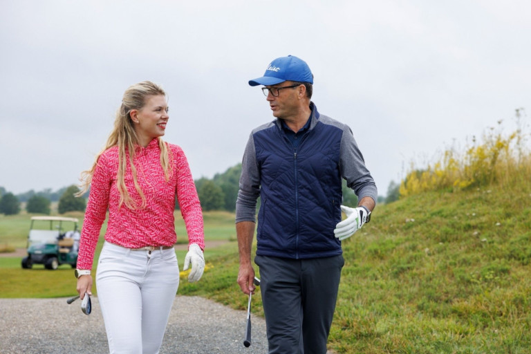 Zwei Personen beim Golfspielen unterhalten sich auf einem Golfplatz – loecher fragen