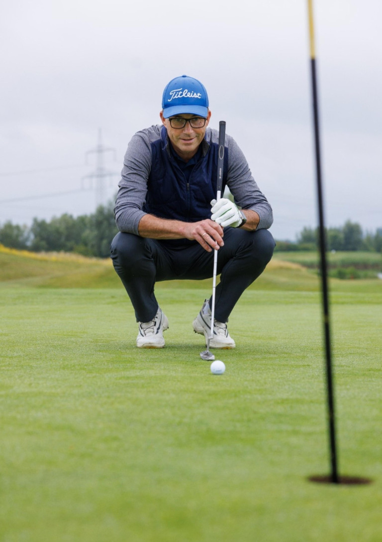 Golfer beim Ausrichten eines Putts auf dem Golfplatz – loecher fragen