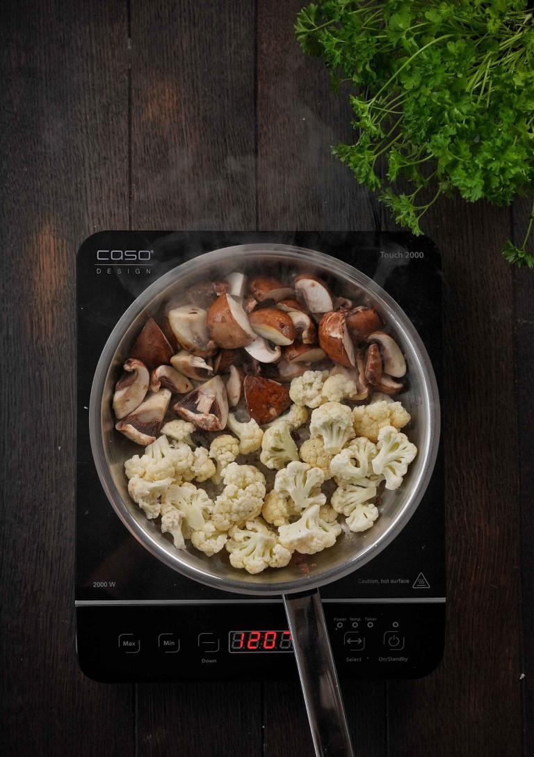 Nobilis kocht: Frische Champignons und Blumenkohl in einer Pfanne auf einem Induktionskochfeld