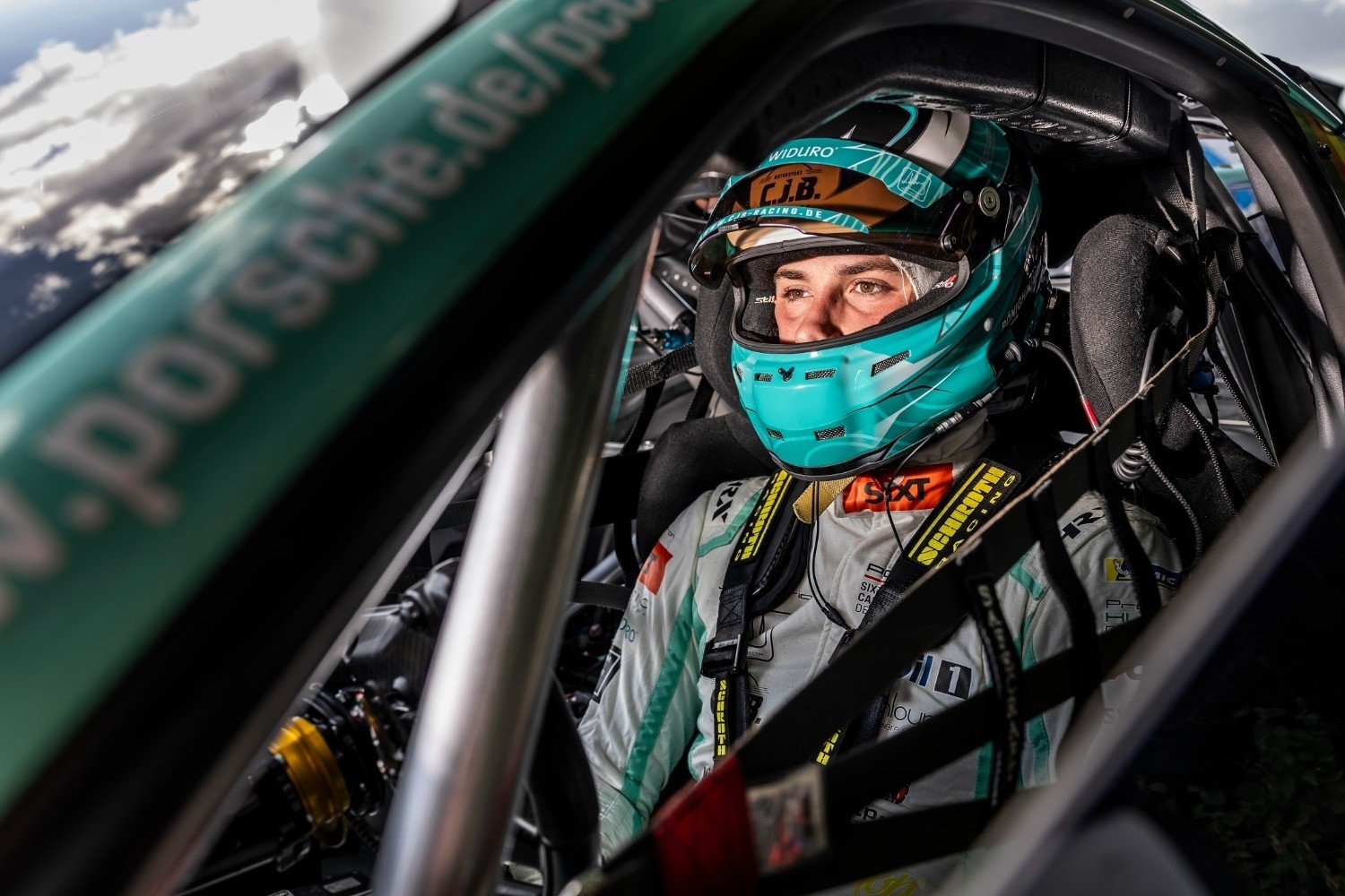 Rennfahrer im Porsche Rennwagen – Motorsport Innenansicht Rennfahrer mit Helm im Cockpit eines Porsche Rennwagens