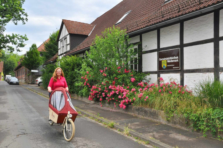 Sonja de Vries mit Lastenrad vor der Gemeindebibliothek Wedemark in Bissendorf