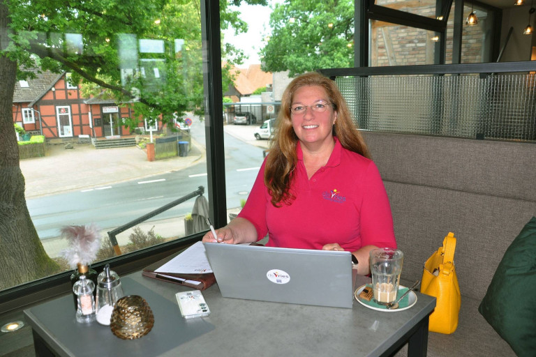 Sonja de Vries arbeitet am Laptop in einem Café