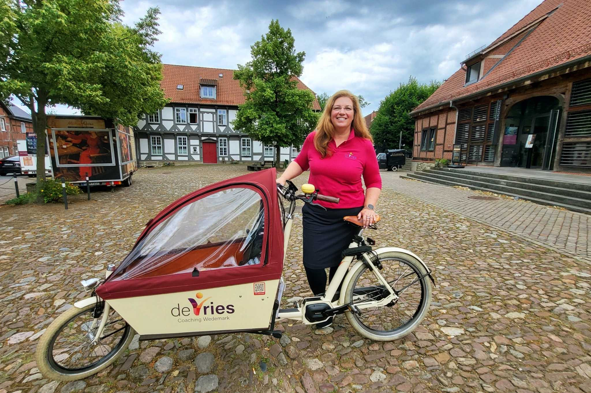 Sonja de Vries mit Lastenfahrrad von de Vries Coaching Wedemark auf einem historischen Platz