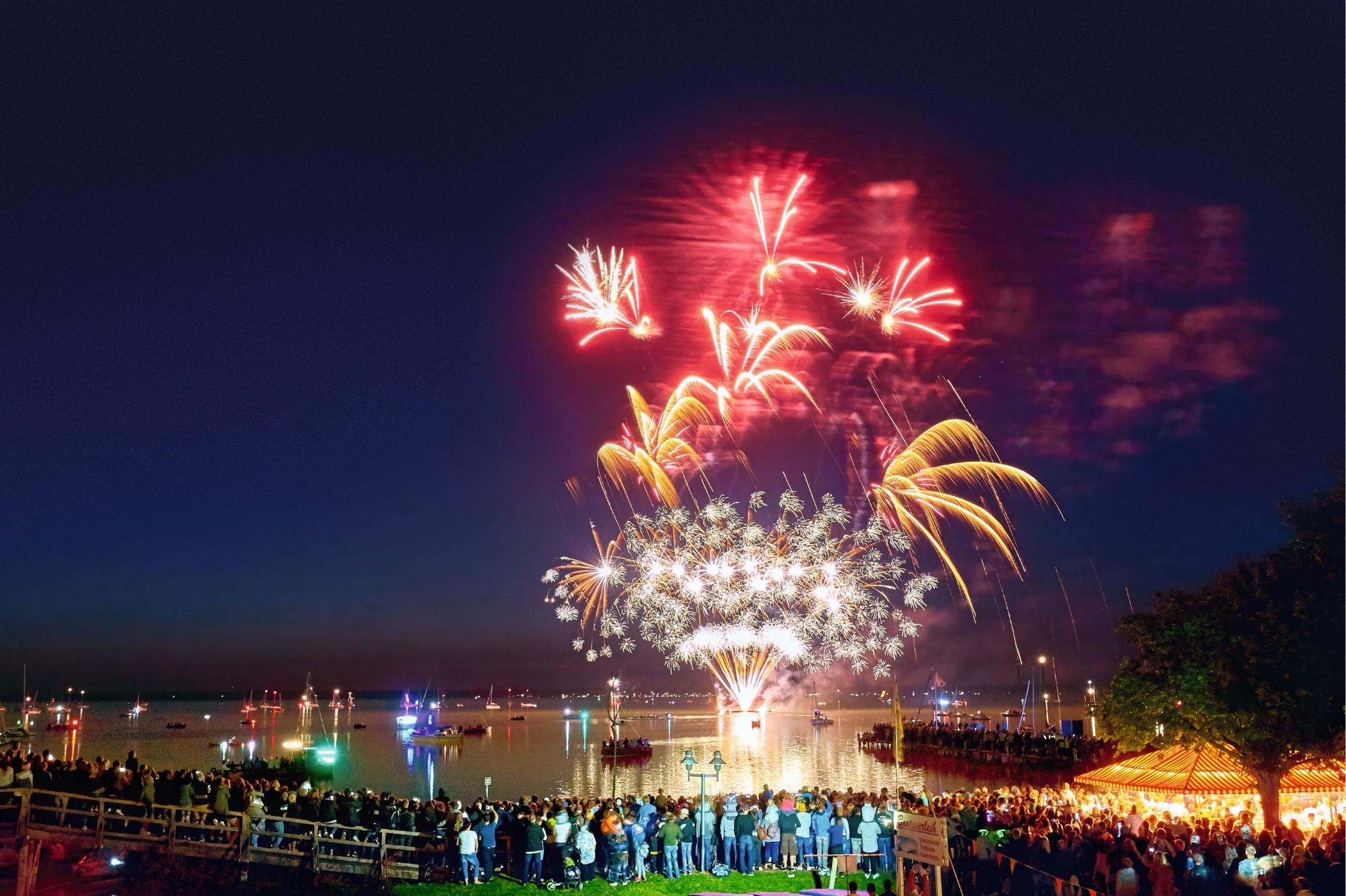 Feuerwerk am Steinhuder Meer mit Menschenmenge am Ufer bei Nacht