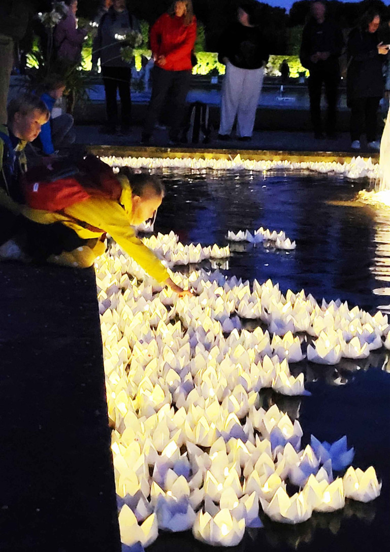 Sommerfest Großer Garten – beleuchtete Papierboote am Wasser bei Nacht Sommerfest im Großen Garten mit leuchtenden Papierbooten auf dem Wasser am Abend