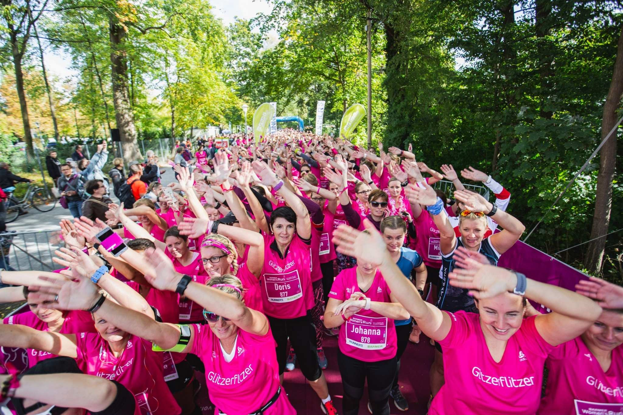 Frauenlauf-Event mit vielen Teilnehmerinnen in pinken Shirts beim Start des Fem Run