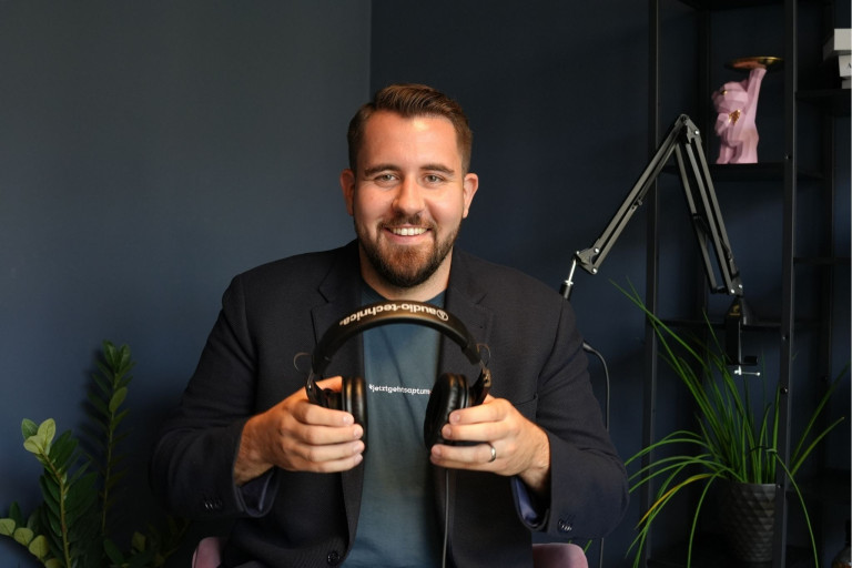 Dominik Talhof hält Audio-Technica Kopfhörer in einem modernen Büro