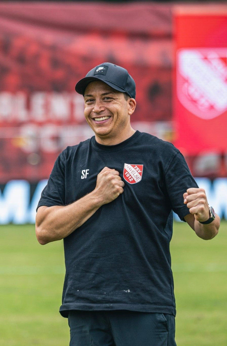 Trainer des TSV Havelse auf dem Spielfeld mit Vereinslogo auf dem Shirt